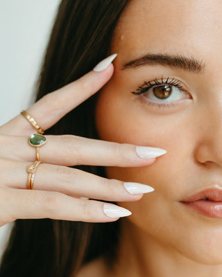 Focus on eye with beautiful stacking rings on fingers